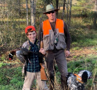 Our guide, Jonathan Enfinger, with a young hunter showing off his pheasant on a hunt in Mobile, AL